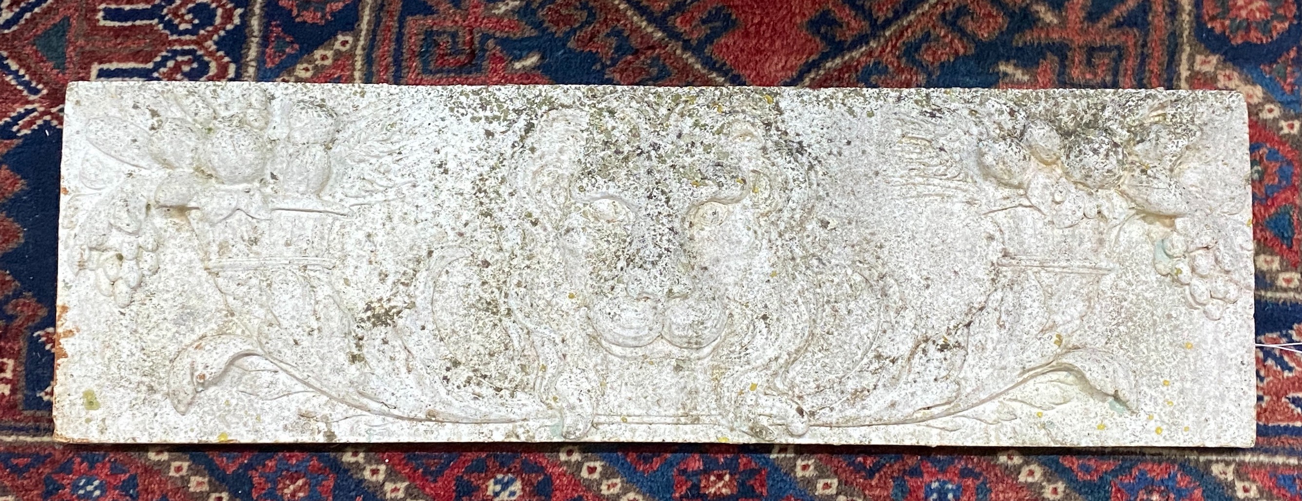 A rectangular reconstituted stone garden plaque with lions, width 76cm